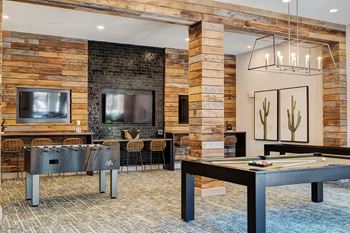 A modern living room with a pool table and a fireplace.